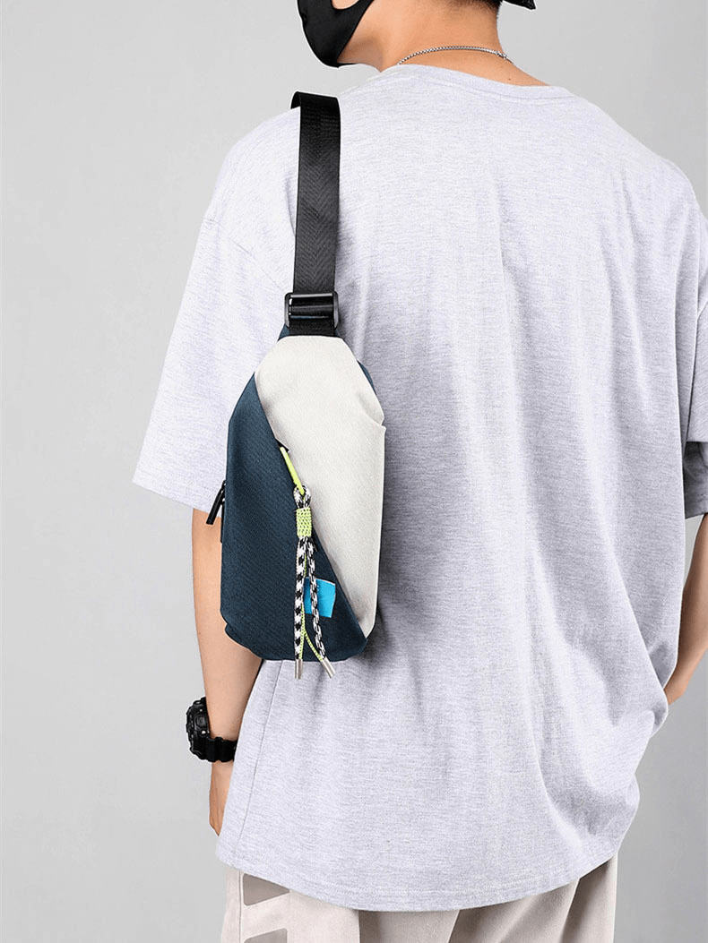 Man wearing a waterproof crossbody chest bag with removable pendant, stylish panelled design, made of Oxford fabric.